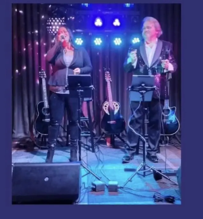 A picture of a women singing an song with a man
